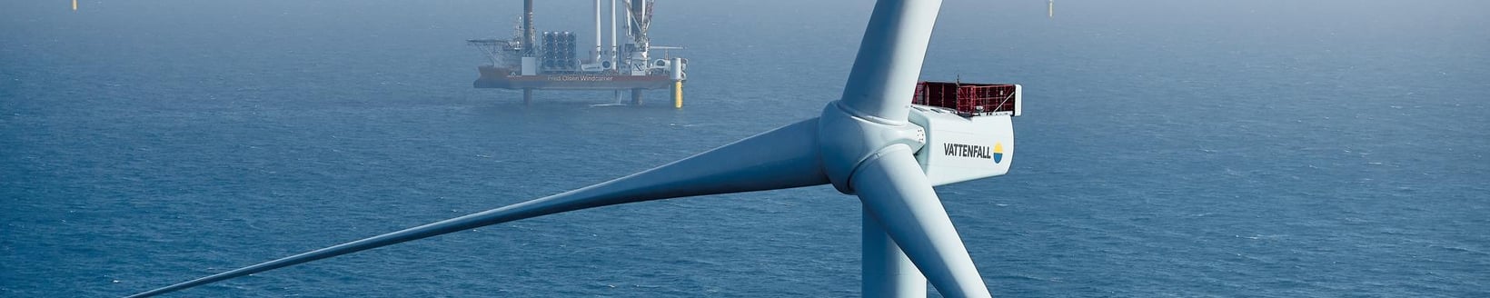 Offshore-Windkraftanlage im Windpark Horns Rev 3 mit einem Industrieschiff im nebligen Hintergrund. Offshore-Windkraftanlage im Windpark Horns Rev 3 mit einem Industrieschiff im nebligen Hintergrund.