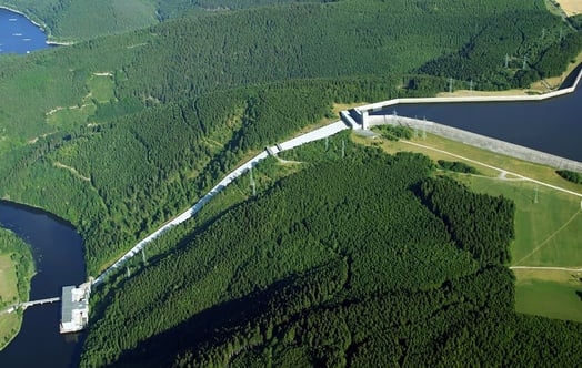 Aerial view of the Hohenwarte II pumped storage power plant and reservoir surrounded by dense forest.