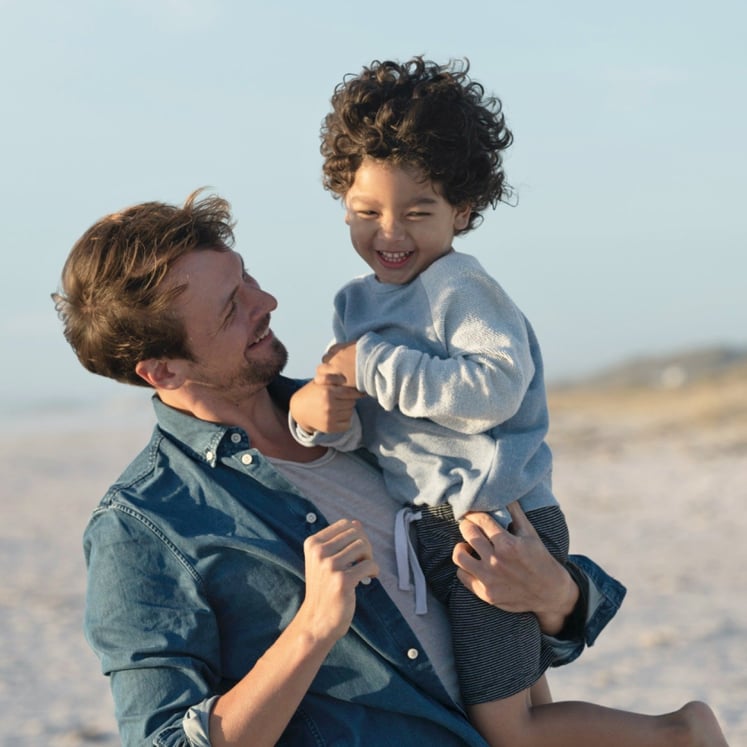 A father and a young son on the beach / Mann mit Junge auf dem Arm über den Strand gehend A father and a young son on the beach / Mann mit Junge auf dem Arm über den Strand gehend